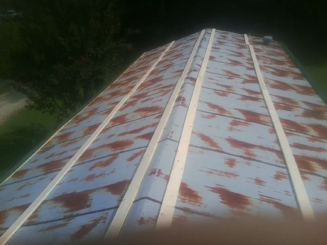 Rusted metal roof panels with new wood purlins before replacement — Storm Damage Roof Repair in Hume by Roofing Brothers