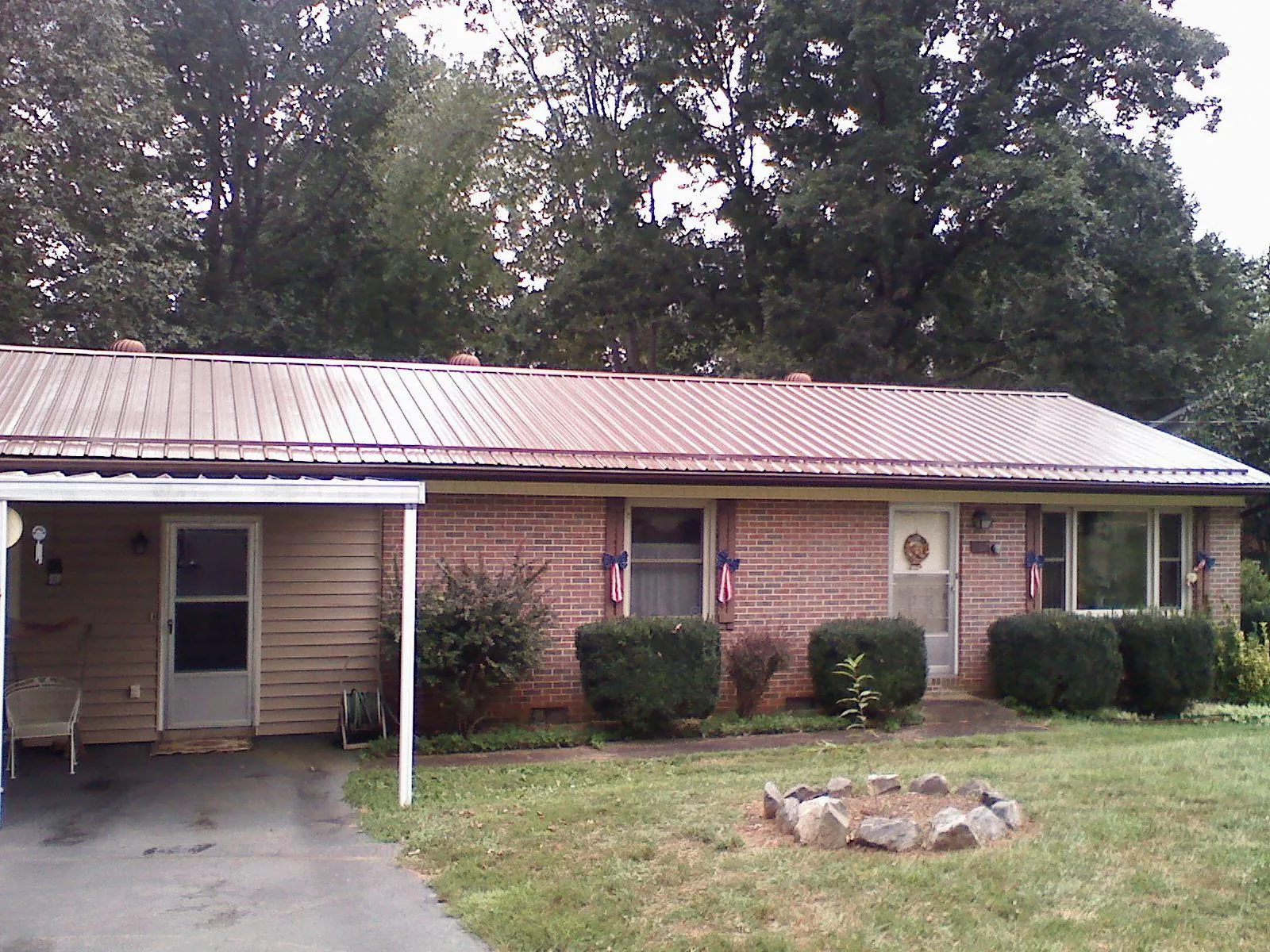 Bronze metal roof and carport on a brick ranch home — Roof Repair work by our crew in Hume
