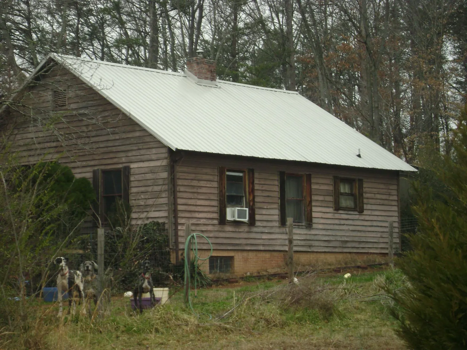 White metal roof on an old wood sided farmhouse, from a Metal Roof Installation job in Hume